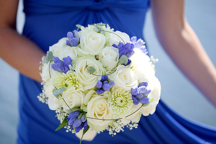 brudbukett med vita rosor och blå blommor