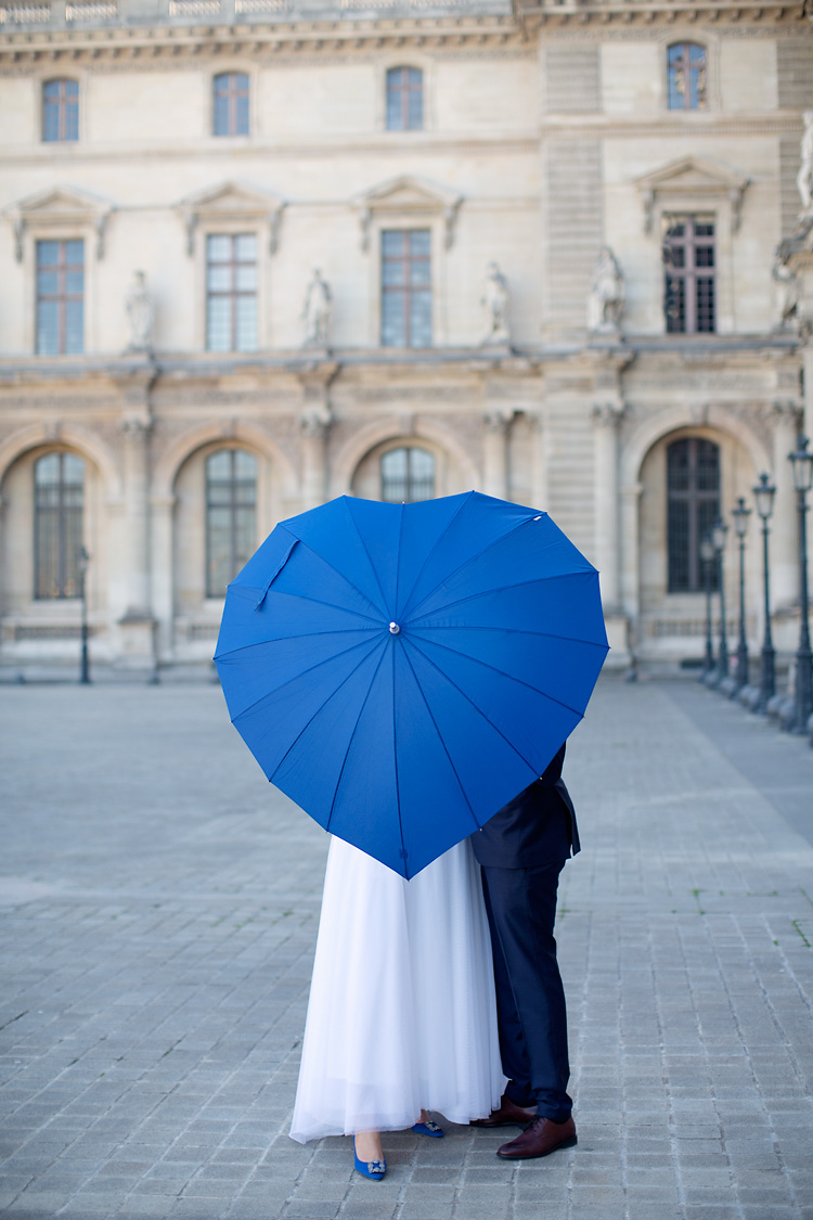 Blått paraply och brudpar